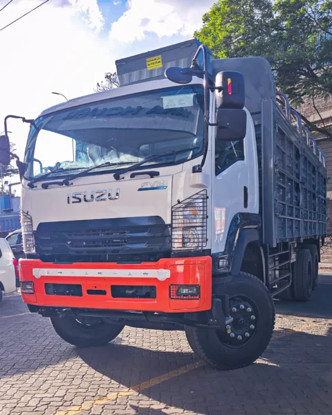 Front view of an Isuzu FVZ 34 cargo truck with a bright orange bumper and grey livestock body.