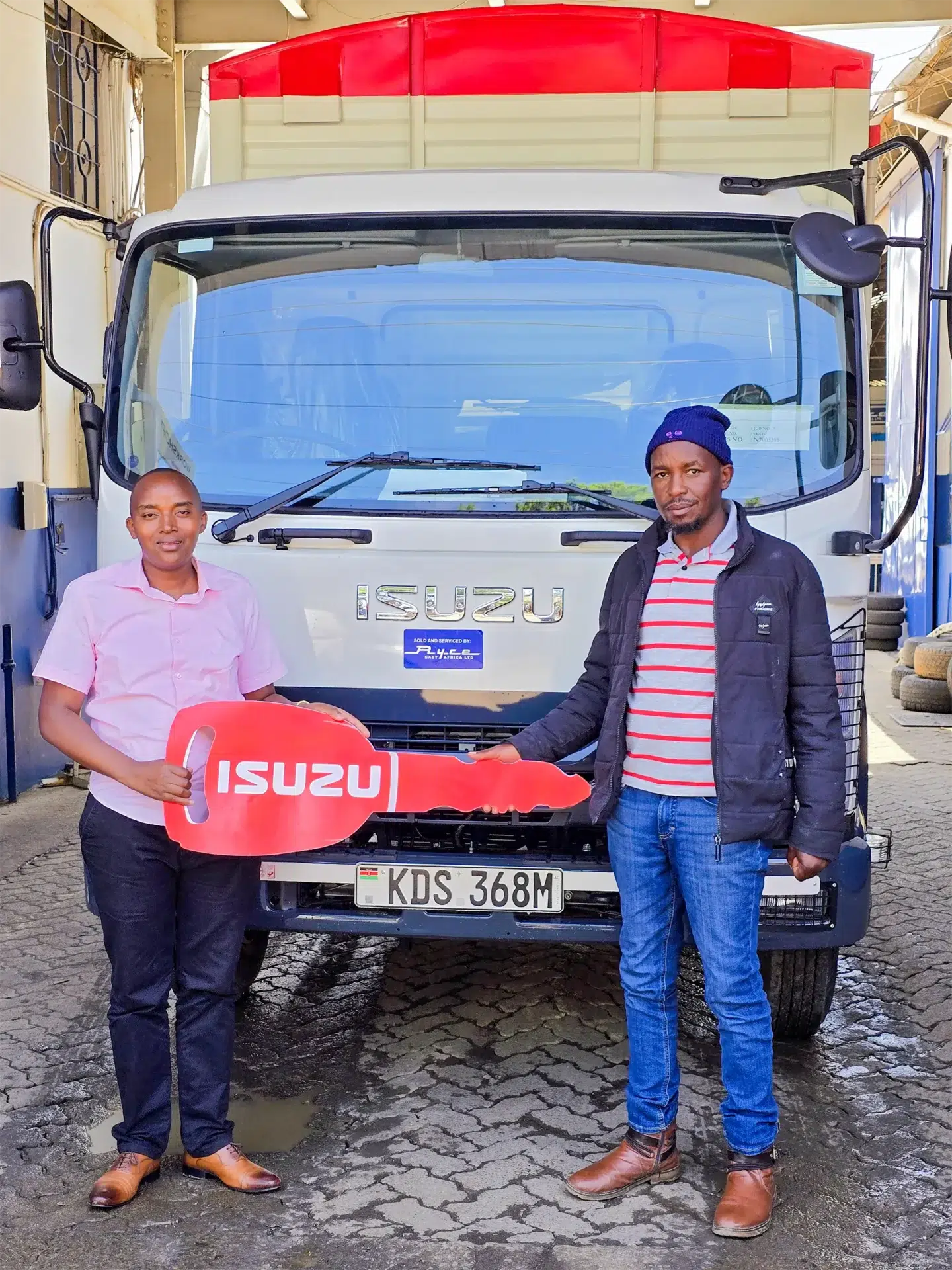 A representative from Highburry Agri Enterprises receiving their brand-new Isuzu FRR 90 BLUEPOWER Truck from Wang'ombe, a top Isuzu sales representative in Kenya, during the official handover ceremony.