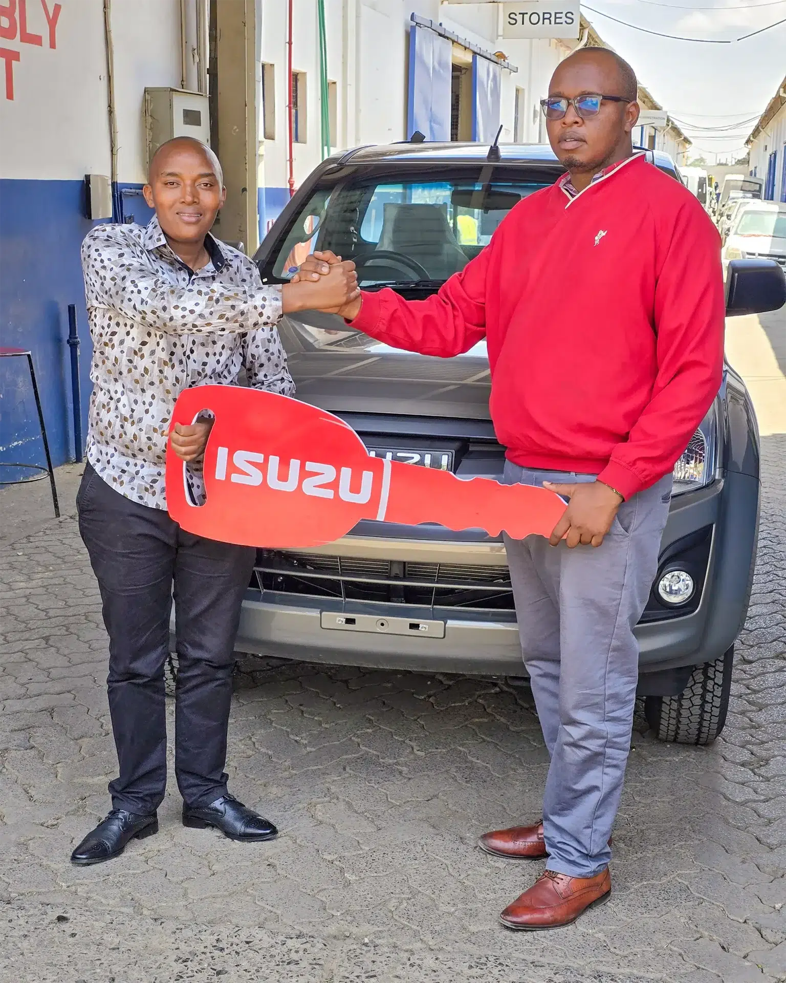 Wang'ombe, a top Isuzu sales representative in Kenya, hands over an Isuzu D-Max Single Cab Pick-up to a satisfied TOSHLEE TRADERS representative. Buy Isuzu truck Nairobi today!