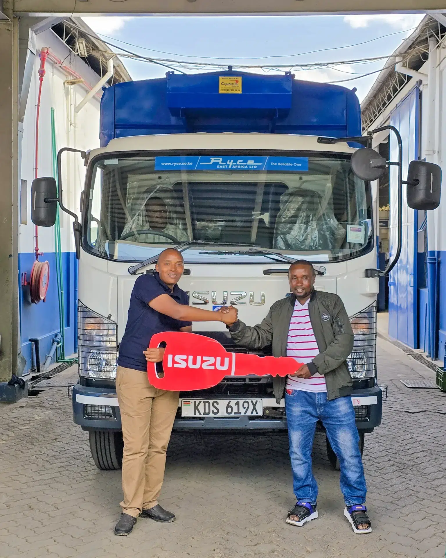 Wang'ombe, a top Isuzu sales representative in Kenya, hands over an Isuzu FRR 90 BLUEPOWER truck to a satisfied customer, Mr. Cloudial Mwangi Munene, at Ryce East Africa dealership.